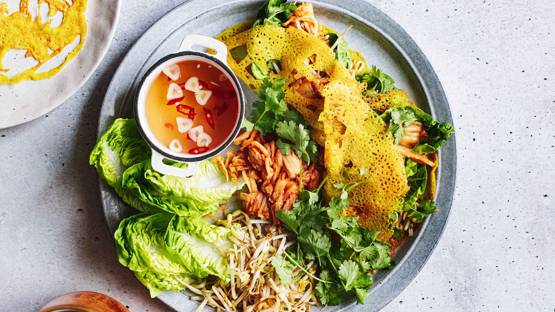 Crispy turmeric pancakes with kimchi, chilli dipping sauce and sprouts