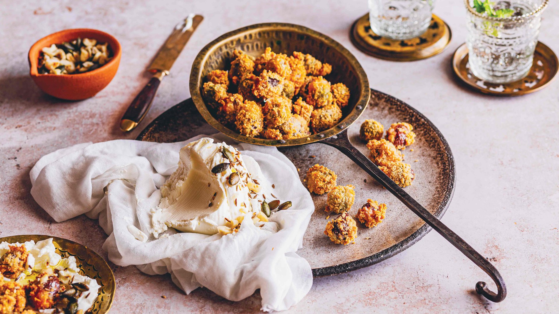 Deep fried stuffed olives with seeded yoghurt dip