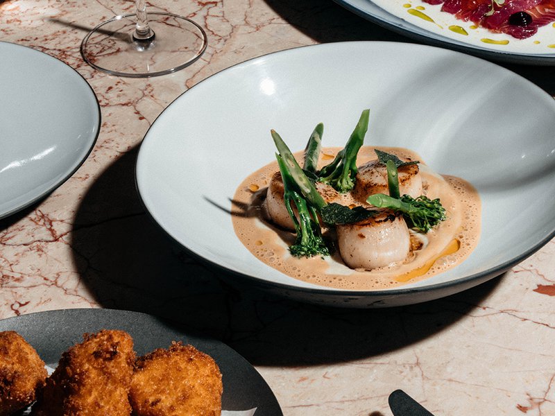 The Hokkaido scallops are flanked by marinated salmon and fried Camembert │ Mixologists whip up creative mocktails at the bar