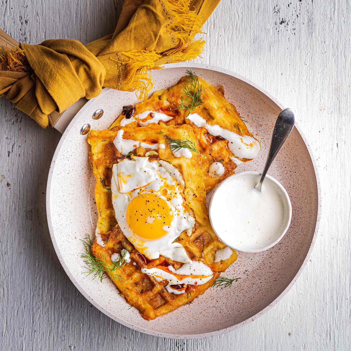 Potato rosti waffles with fried eggs and horseradish dressing