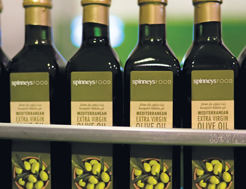 Bottles of SpinneysFOOD Mediterranean Extra Virgin Olive Oil in the assembly line