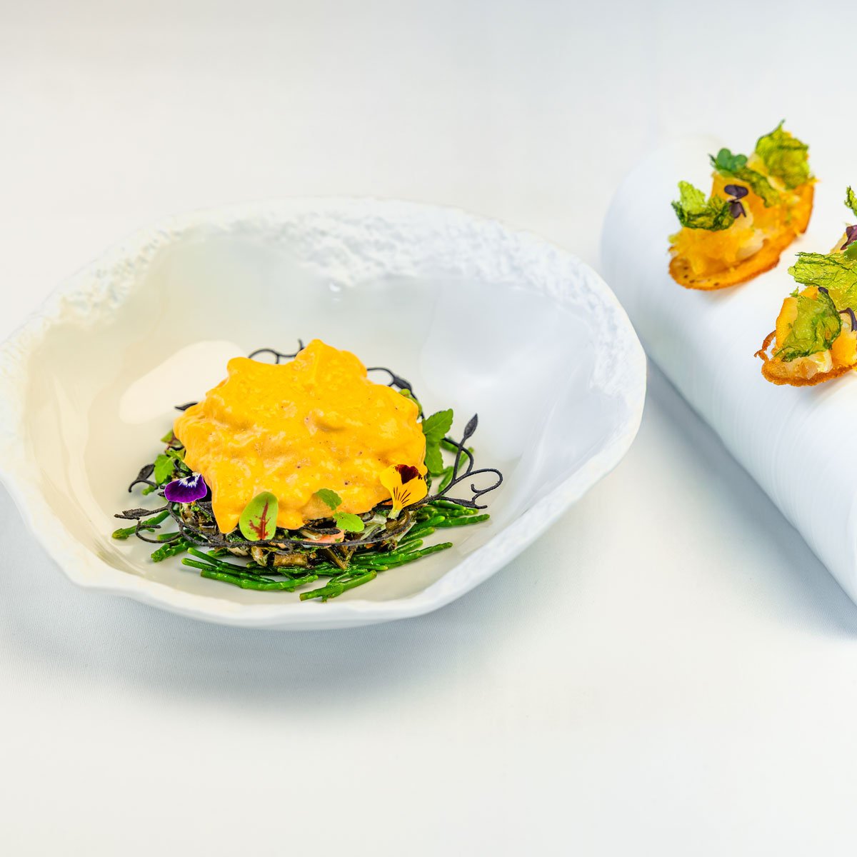 Shellfish marinière with seaweed. Served with sea urchin Chantilly and haddock toast